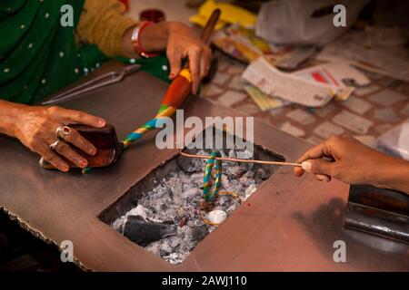 Indien, Rajasthan, Shekhawati, Nawalgarh, die traditionellen lac Bangles mit der Hand machen, sich zu Spiralmuster verdrehen, Gold und blaue Farbe bangen, während Stockfoto