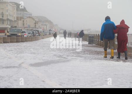 Hastings, East Sussex, Großbritannien. Februar 2020. Wetter in Großbritannien: Das Met-Büro hat eine gelbe Warnung für Wind im Süden mit vorhergesagten Winden von 75 mph herausgegeben, als Gale Force Winde und Regen die Südostküste in Hastings, East Sussex trafen. Riesige Mengen Meeresschaum werden auf die Strandpromenade geblasen, während die Menschen mit Elementen kämpfen. ©Paul Lawrenson 2019, Photo Credit: Paul Lawrenson/Alamy Live News Stockfoto