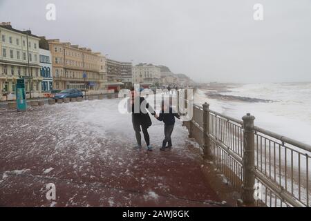 Hastings, East Sussex, Großbritannien. Februar 2020. Wetter in Großbritannien: Das Met-Büro hat eine gelbe Warnung für Wind im Süden mit vorhergesagten Winden von 75 mph herausgegeben, als Gale Force Winde und Regen die Südostküste in Hastings, East Sussex trafen. Riesige Mengen Meeresschaum werden auf die Strandpromenade geblasen, während die Menschen mit Elementen kämpfen. ©Paul Lawrenson 2019, Photo Credit: Paul Lawrenson/Alamy Live News Stockfoto