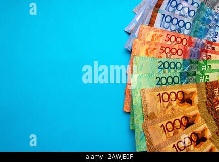 Kasachische Landeswährung - tenge, Draufsicht. Tausend, zweitausend, fünftausend, zehntausend Tenge. Geldscheine auf blauem Hintergrund mit Stockfoto