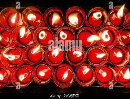 Brennende rote chinesische Kerze in Glas mit leichter Flamme Draufsicht abstrakter Hintergrund Stockfoto