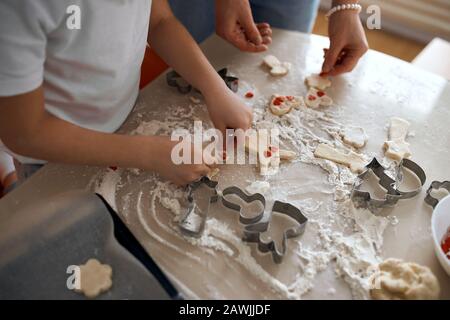 Mutter und Tochter bereiten selbstgemachte lebkuchenplätzchen aus nächster Nähe zubereitete zugeschnittene Schußbrötchen, Dekoration, Vorbereitung für den Urlaub vor Stockfoto