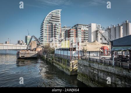 Wohnungsbau entlang der Themse und Hanson Ready Mix Concrete, Pier Terrace, Jews Row, Wandsworth, London, SW18, England, Großbritannien. Stockfoto