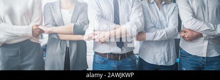 Kreative Teambesprechung verbindet sich. Junge Geschäftsleute halten sich die Hände. Einigkeit und Teamarbeit. Stockfoto