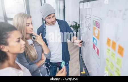 Designer, die die Entwicklung von UX-Anwendungen auf der Website zeichnen. Konzept der Benutzererfahrung. Stockfoto