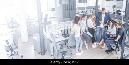 Team bei der Arbeit. Gruppe junger Geschäftsleute, die in kreativ modernen Büros zusammenarbeiten. Stockfoto