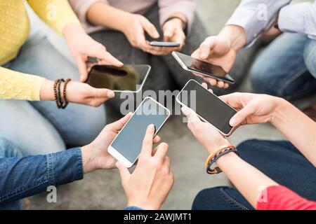 Gruppe junger Hipster, die das Telefon in den Händen halten. Freunde, die Spaß mit Smartphones haben. Stockfoto