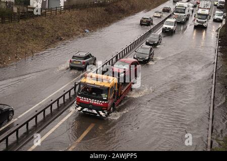 Der Verkehr passiert Wasser auf der A66 bei Bowes im County Durham, als Storm Ciara in Großbritannien eintrifft. Stockfoto