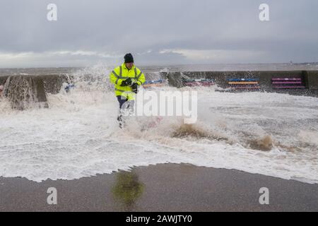 New Brighton, Wirral, Großbritannien. Februar 2020. Fotografen nutzen die Gelegenheit, die von Storm Ciara verursachten Wellen zu erfassen, während sie in die Promenade von New Brighton auf der Wirral stürzen. Ein Fotograf wird von den Wellen, die über die Promenadenwand krachen, von den Füßen gefegt. Kredit: Christopher Middleton/Alamy Live News Stockfoto