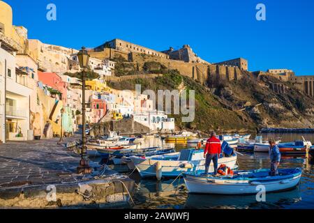 Procida, ITALIEN - 3. JANUAR 2020 - Blick auf die Corricella-Bucht im Sonnenuntergang, einem romantischen Fischerdorf in Procida, Italien Stockfoto
