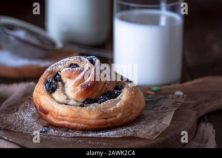 Kruffine mit Rosinen und getrockneten Aprikosen, oben mit Puderzucker bestreut. Festliche Stimmung. Stockfoto