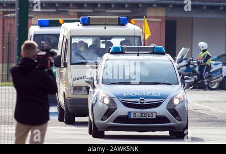 Berlin, Deutschland. Februar 2020. Von der Polizei begleitet fährt ein Krankenwagen vom Militärteil des Flughafens Tegel auf die Straße. Ein Flugzeug der Bundeswehr ist in Berlin mit Rückkehrern aus der chinesischen Stadt Wuhan gelandet, die vom Corona-Virus stark betroffen ist. Kredit: Soeren Stache / dpa-Zentralbild / ZB / dpa / Alamy Live News Stockfoto