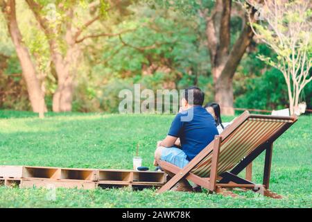 Glück Paar auf einem Sommerurlaub sitzen auf Stühlen im öffentlichen Park zu entspannen. Stockfoto