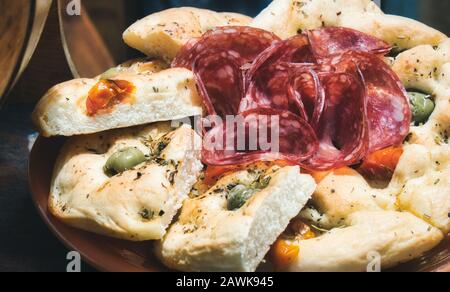 Platte mit Focaccia-Brot mit Scheiben von Salami und Oliven Stockfoto