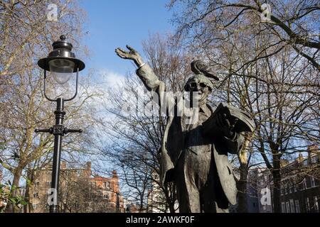 Eine Taube, die auf einer Statue von Fenner Brockway, Baron Brockway, auf dem Red Lion Square, London, Großbritannien sitzt Stockfoto