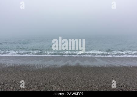 Sandstrände mit ruhigem Meer an einem nebligen Tag Stockfoto