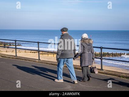 Ein Paar, die auf dem Prom in Hornsea East Yorkshire spazieren gehen. Stockfoto