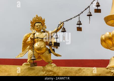 Statue eines goldenen Kriegers, der eine Schnur mit Glocken hält. Auf dem Dach des Jokhang-Tempels. Stockfoto