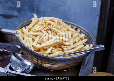 Blick auf hausgemachte und frisch gebackene Pommes frites in einer Metallschale mit Essleinen. Köstlicher Snack, knackig und knackig. Stockfoto