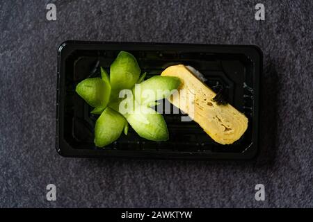 Nehmen Sie den japanischen Dashimaki Tamago aus Ei Sushi, Mariniert mit Dashi Suppe Mirin, Shoyu, Blume Geformte Gurke und Reis in Kunststoffbehälter B Stockfoto