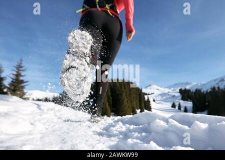 Nahschuhe der in den Winterbergen laufenden Wegerin auf dem Schnee. Stockfoto