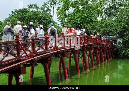 Hanoi, Vietnam, 3. August 2010: Vietnamesen, die auf Der roten Huc-Brücke zur Jade-Insel spazieren gehen. Hanoi, Vietnam Stockfoto