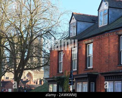 Dreistöckiges viktorianisches Reihenhaus am Westgate in Lincoln mit Lincoln Cathedral im Hintergrund am hellen Wintertag Stockfoto