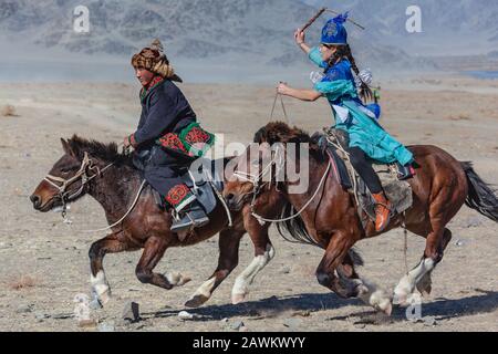 Ulgii, Mongolia, Oktoberfest der goldenen Adler traditionelle kasachische Spiele Pferd Jagd Paar Stockfoto