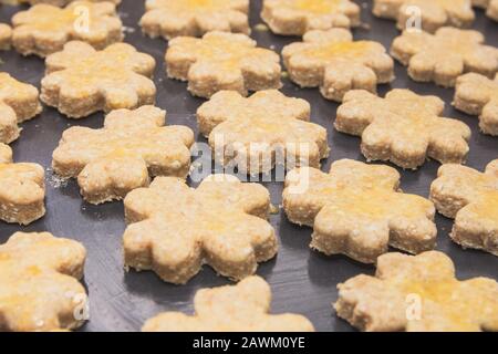 Vierblättrige Clover Shaped Cottage Cheese Cookies auf schwarzem Backblech Stockfoto