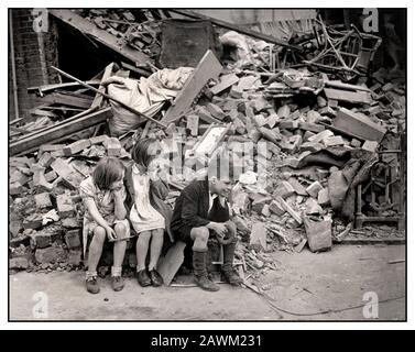 Die Kinder von East London aus den 40er Jahren des zweiten Weltkriegs in London, die durch die zufälligen Londoner Blitz Bomben der nächtlichen Bombenangriffe auf Nazi-Deutschland obdachlos geworden sind und außerhalb der Trümmer ihres Wohnhauses warteten. September 1940. East London UK Stockfoto