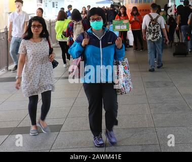 Hongkong, CHINA - 29. APRIL 2017: Asiaten mit einer Frau tragen eine chirurgische Maske zum Virenschutz im Inneren der Fußgängerbrücke. Stockfoto