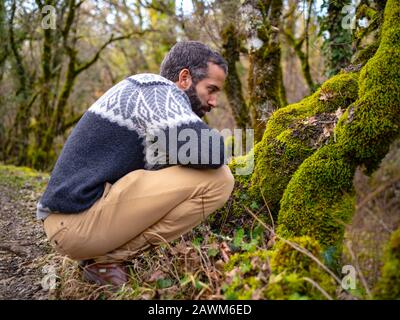 Ein Mann, Der Etwas Im Moss Beobachtet Stockfoto