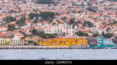 Küstenlandschaft von Funchal, der Hauptstadt der Insel Madeira, Portugal. An der Küste befinden sich bunte Gebäude Stockfoto