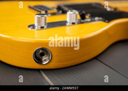 Jack Eingang einer gelben und lackierten klassischen amerikanischen E-Gitarre mit Chrom-Metallic-Elementen Stockfoto