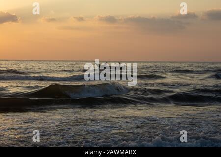 Schöner Blick auf die Wellen und die Fischerboote entlang des Marina Strandes während des Sonnenaufgangs, Chennai, Indien. Fischer wagten sich während der e Stockfoto