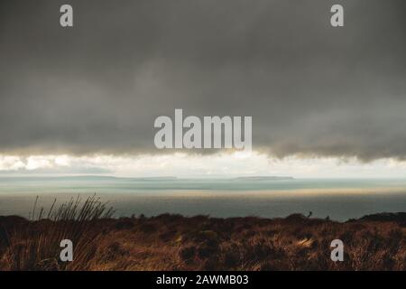 Blick vom Mull of Kintyre nach Nordirland und zur Rathlin-Insel bei dramatischen Wetterbedingungen im Winter, Schottland, Großbritannien Stockfoto