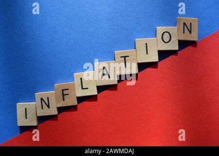 Inflation in Buchstaben aus 3D-Holzalphabet auf rotem und blauem Hintergrund Stockfoto