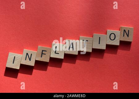 Inflation in Buchstaben aus 3D-Holzalphabet auf rotem Hintergrund Stockfoto