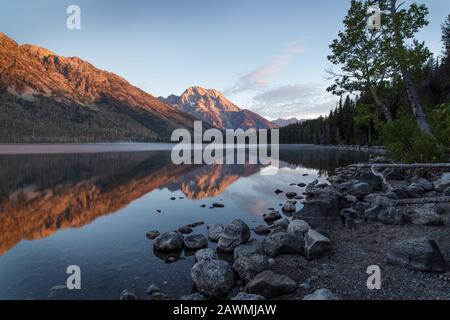 Sunrise - Grand Teton National Park. Sonnenaufgang Reflexionen auf dem schönen Jenny Lake. Jenny Lake im Grand Teton National Park wurde approxima gebildet Stockfoto