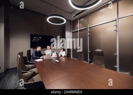 Porträt von drei Mitarbeitern, die Geschäftsplan im Büro besprechen. Stockfoto