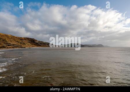 Blick auf die Juraküste an der Lyme Bay in Dorset. Fossil tragende Klippen in der Ferne mit Meer im Vordergrund. Stockfoto