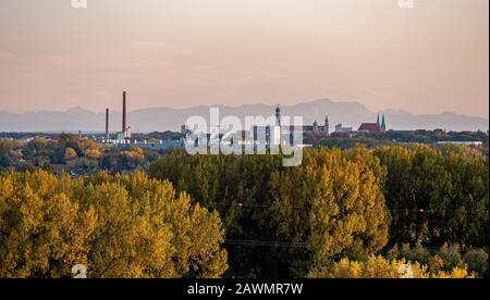 Panoramabild der Skyline von Augsburg bei Sonnenuntergang mit Bergen im Hintergrund. Stockfoto