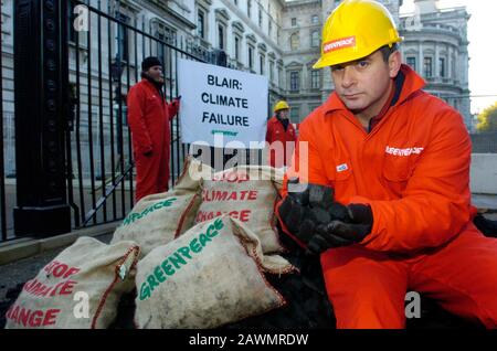 Greenpeace-Demonstranten verlassen einen Kohlehaufen vor der Downing Street, die 2005 gegen den Klimawandel protestiert. Der Premierminister hatte versprochen, die Emission von klimaschädlichen Umweltverschmutzung in Großbritannien zu reduzieren. Stockfoto