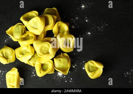 Konzept der italienischen Küche. Tortellini isoliert auf dunklem Hintergrund. Stockfoto