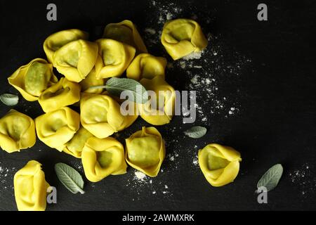 Konzept der italienischen Küche. Tortellini isoliert auf dunklem Hintergrund. Stockfoto