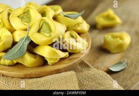 Konzept der italienischen Küche. Tortellini isoliert auf Holzhintergrund. Stockfoto