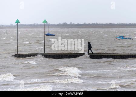 Person auf dem Wellenbrecher in der abgehackten Themse Mündung, als Sturm Ciara das Wetter in Southend on Sea, Essex, Großbritannien beeinflusst Stockfoto