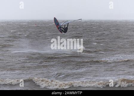 Ein Windsurfer, der auf rauer See in die Luft in der Themsemündung sprang, während der Sturm Ciara das Wetter in Southend on Sea, Essex, Großbritannien beeinträchtigt. In Der Luft Stockfoto