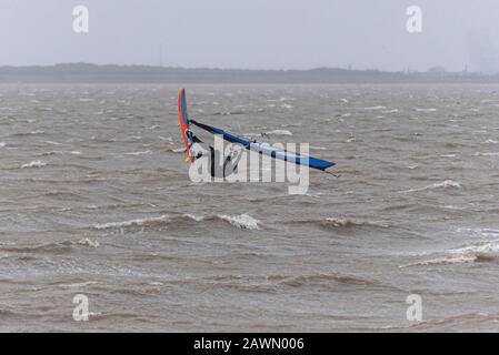 Ein Windsurfer, der auf rauer See in die Luft in der Themsemündung sprang, während der Sturm Ciara das Wetter in Southend on Sea, Essex, Großbritannien beeinträchtigt. Fliegen Stockfoto