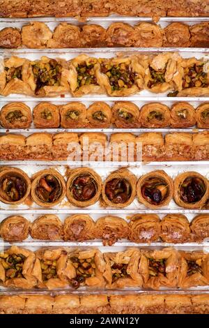 Arabische Baklava-Desserts mischen sich in Reihen im Hintergrund Stockfoto